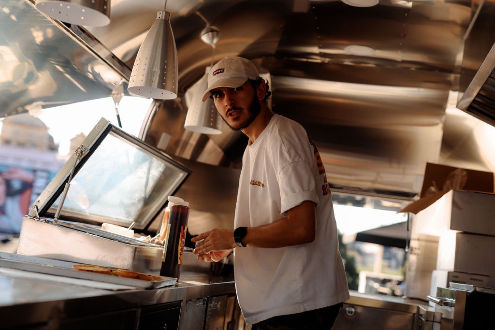 Membre de l'équipe Marty's préparant un burger à l'intérieur du food truck lors de l'événement Super Wet
